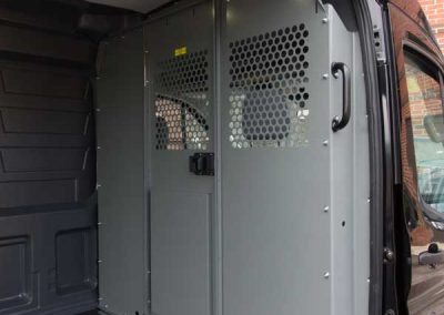 Ford Transit cargo van bulkhead partition with perforated view-through areas.